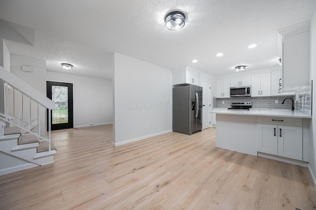 260 Old Coach Pl, Canal Winchester, OH 43110 - kitchen featuring appliances with stainless steel finishes, open floor plan, a textured ceiling, light wood-style flooring, and light countertops