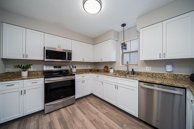 29 Victorian Gate Way, Columbus, OH 43215 - kitchen featuring stainless steel appliances, white cabinets, light wood finished floors, and a textured ceiling