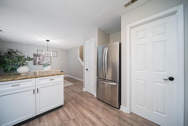 29 Victorian Gate Way, Columbus, OH 43215 - kitchen with freestanding refrigerator, white cabinetry, stone countertops, light wood-style flooring, and hanging light fixtures