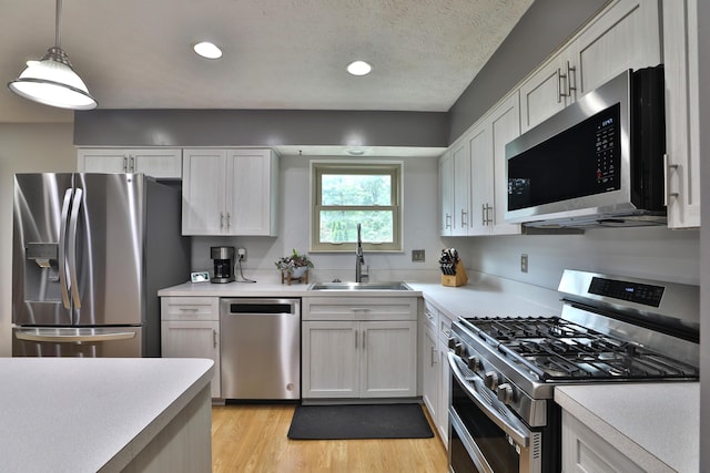 677 Fallside Ln, Westerville, OH 43081 - kitchen with appliances with stainless steel finishes, light countertops, recessed lighting, light wood finished floors, and white cabinetry