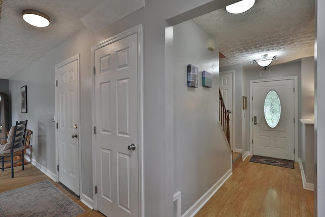 677 Fallside Ln, Westerville, OH 43081 - foyer entrance with a textured ceiling, light wood-type flooring, and stairs