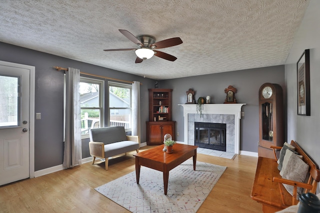 677 Fallside Ln, Westerville, OH 43081 - living area featuring ceiling fan, a fireplace, light wood finished floors, and a textured ceiling