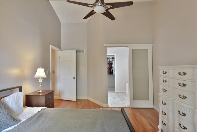 677 Fallside Ln, Westerville, OH 43081 - bedroom with light wood-style floors, a spacious closet, high vaulted ceiling, and a ceiling fan