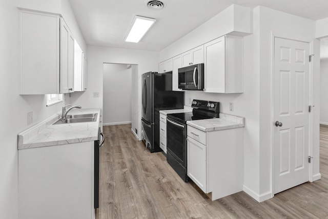303 Rocky Fork Dr N, Columbus, OH 43230 - kitchen with black range with electric stovetop, stainless steel microwave, light wood finished floors, and light countertops