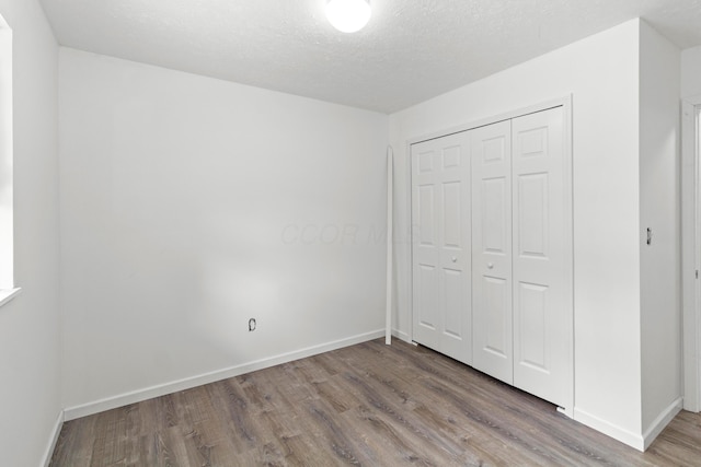 303 Rocky Fork Dr N, Columbus, OH 43230 - unfurnished bedroom featuring wood finished floors, a closet, and a textured ceiling