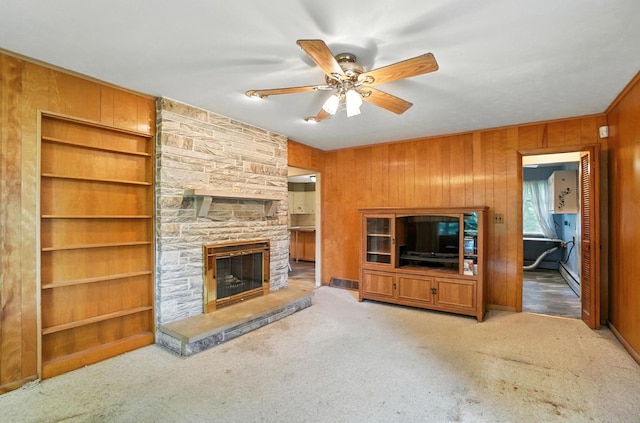 5050 Bixby Rd, Groveport, OH 43125 - unfurnished living room with a stone fireplace, a ceiling fan, carpet, wooden walls, and built in shelves