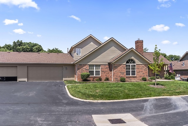 2919 Laurel Wind Blvd, Lewis Center, OH 43035 - view of front facade with driveway, a front yard, brick siding, and a chimney