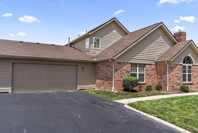 2919 Laurel Wind Blvd, Lewis Center, OH 43035 - view of front facade with brick siding, a shingled roof, driveway, an attached garage, and a chimney