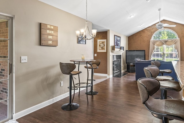 2919 Laurel Wind Blvd, Lewis Center, OH 43035 - dining space with lofted ceiling, wood finished floors, a ceiling fan, a chandelier, and a fireplace with flush hearth