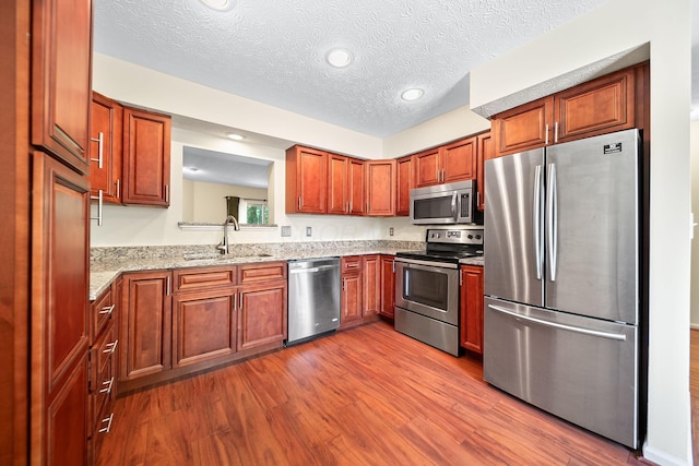 3254 Brookview Way Unit 15, Columbus, OH 43221 - kitchen featuring appliances with stainless steel finishes, dark wood finished floors, light stone countertops, recessed lighting, and a textured ceiling