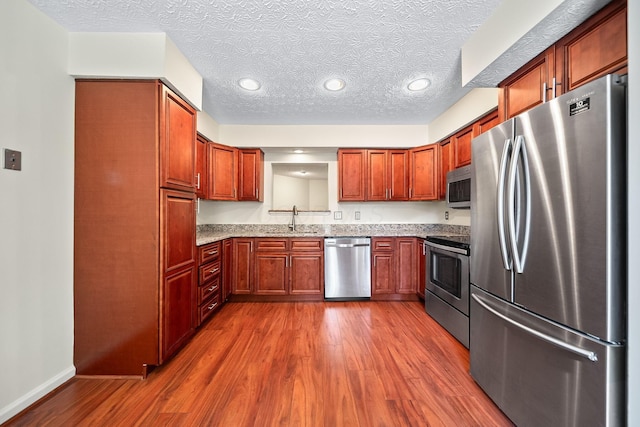 3254 Brookview Way Unit 15, Columbus, OH 43221 - kitchen featuring stainless steel appliances, dark wood finished floors, light stone countertops, recessed lighting, and a textured ceiling