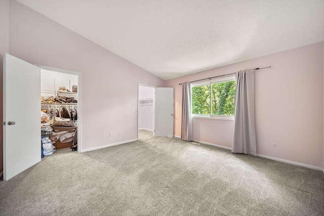 3254 Brookview Way Unit 15, Columbus, OH 43221 - unfurnished bedroom with a walk in closet, vaulted ceiling, and carpet flooring