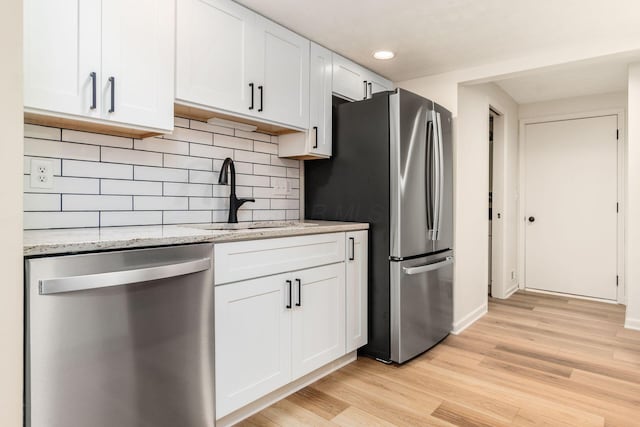 5110 Schuylkill St Unit 33-10, Columbus, OH 43220 - kitchen featuring appliances with stainless steel finishes, light wood-style flooring, tasteful backsplash, white cabinetry, and recessed lighting