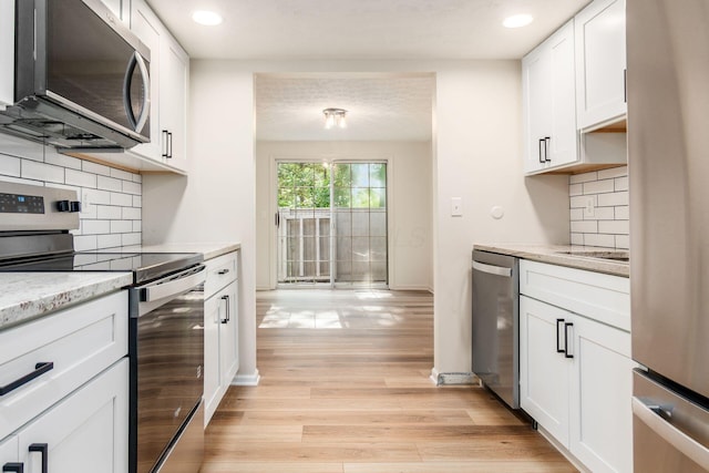 5110 Schuylkill St Unit 33-10, Columbus, OH 43220 - kitchen featuring appliances with stainless steel finishes, white cabinets, light wood-style floors, recessed lighting, and light stone counters