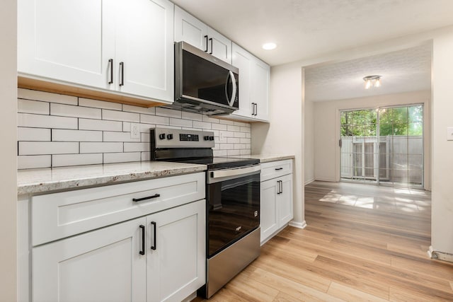 5110 Schuylkill St Unit 33-10, Columbus, OH 43220 - kitchen with appliances with stainless steel finishes, white cabinets, decorative backsplash, light wood-type flooring, and recessed lighting