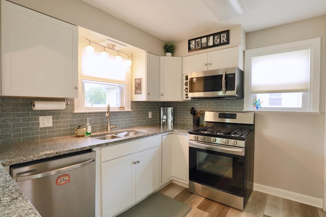 822 Rutter Ave, Lancaster, OH 43130 - kitchen with stainless steel appliances, white cabinets, backsplash, light wood-type flooring, and light stone countertops