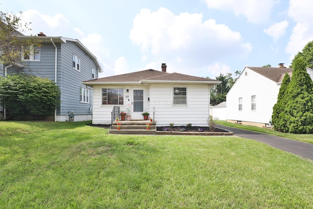 69 Morse Rd, Columbus, OH 43214 - rear view of property featuring a chimney, a lawn, and asphalt driveway