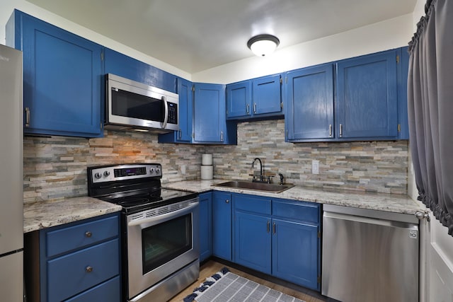 69 Morse Rd, Columbus, OH 43214 - kitchen with stainless steel appliances, blue cabinetry, and backsplash