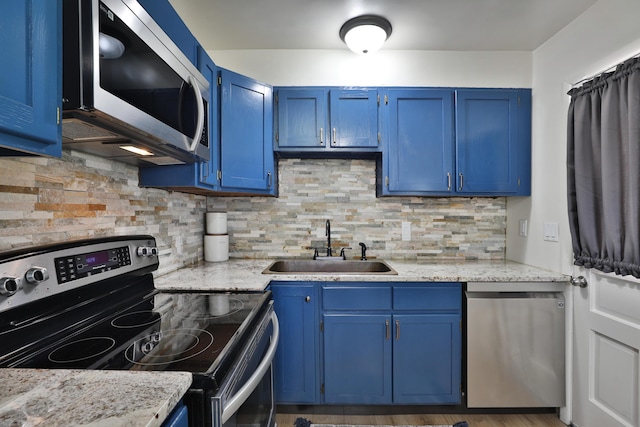 69 Morse Rd, Columbus, OH 43214 - kitchen with stainless steel appliances, blue cabinetry, and decorative backsplash