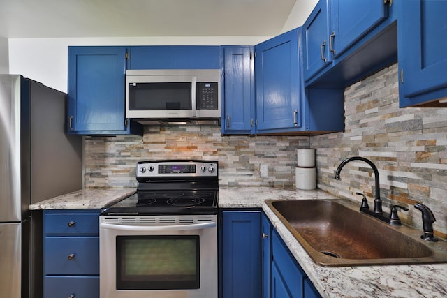 69 Morse Rd, Columbus, OH 43214 - kitchen with appliances with stainless steel finishes, blue cabinetry, and backsplash