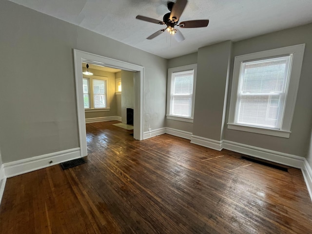 2395 Summit St, Columbus, OH 43202 - empty room with a ceiling fan, dark wood-style flooring, healthy amount of natural light, and a fireplace with flush hearth