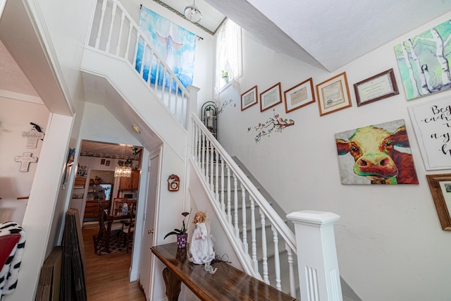 83 2nd St, Shelby, OH 44875 - staircase featuring a chandelier, wood finished floors, and a textured ceiling