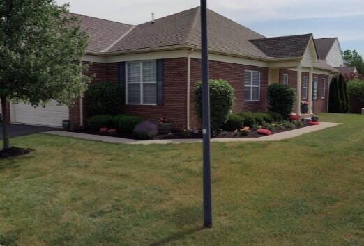 5736 Burke Cir Unit 503, New Albany, OH 43054 - view of property exterior with a lawn, brick siding, and a shingled roof