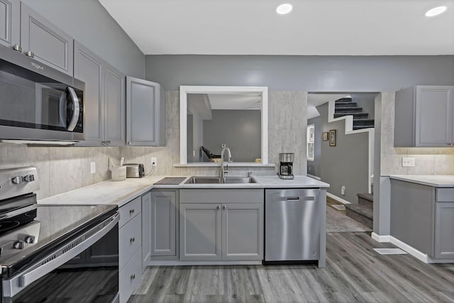 716 N Mount Pleasant Ave, Lancaster, OH 43130 - kitchen with appliances with stainless steel finishes, gray cabinetry, tasteful backsplash, light countertops, and light wood finished floors