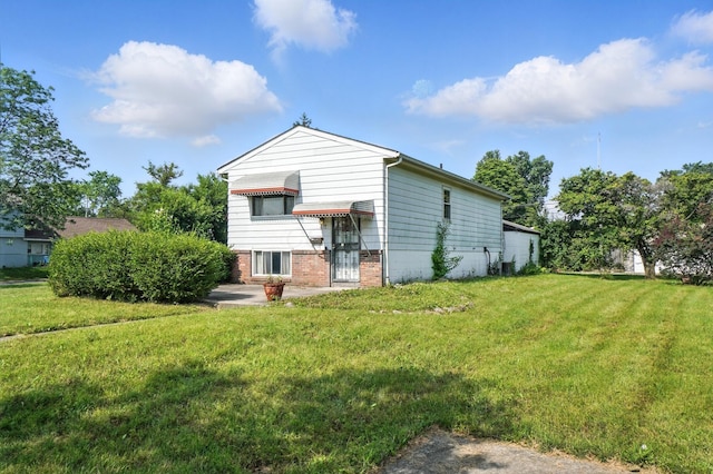 617 Athens St, Columbus, OH 43204 - rear view of house with a lawn and brick siding