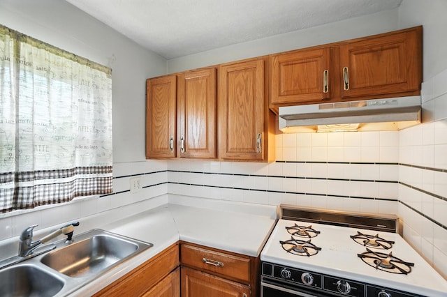 617 Athens St, Columbus, OH 43204 - kitchen featuring under cabinet range hood, range with gas cooktop, light countertops, and brown cabinets
