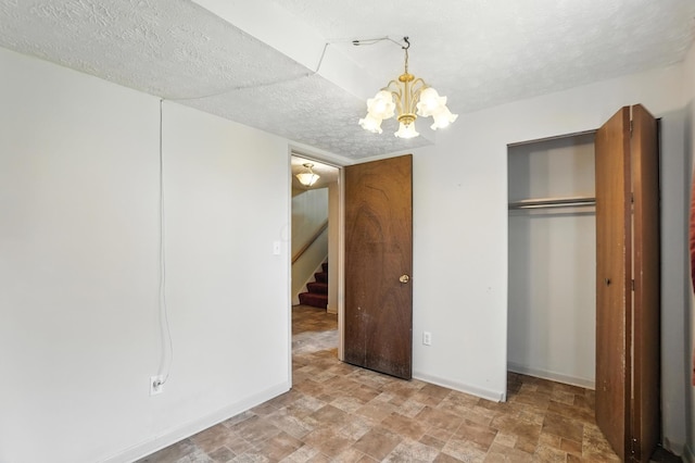617 Athens St, Columbus, OH 43204 - unfurnished bedroom featuring a chandelier, a closet, a textured ceiling, and stone finish flooring