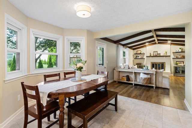 7107 Stone Ct, Columbus, OH 43235 - dining space featuring a textured ceiling, a brick fireplace, and tile patterned floors