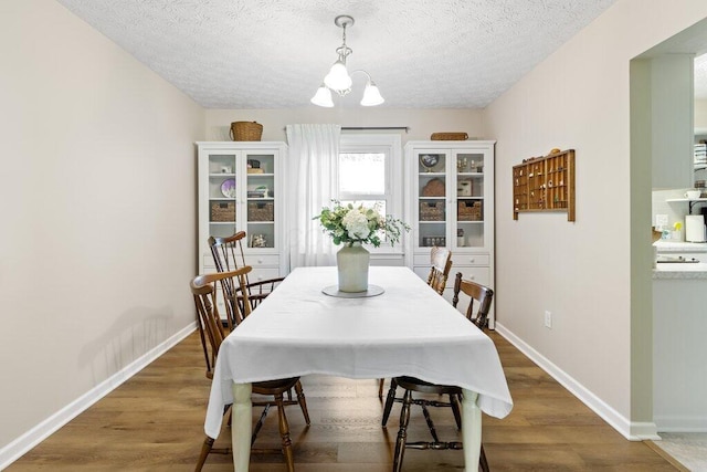 7107 Stone Ct, Columbus, OH 43235 - dining area with a chandelier, a textured ceiling, and wood finished floors