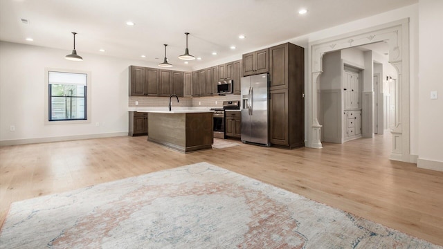 58 Lippert Ln, Buckeye Lake, OH 43008 - kitchen with stainless steel appliances, light countertops, light wood finished floors, tasteful backsplash, and open floor plan