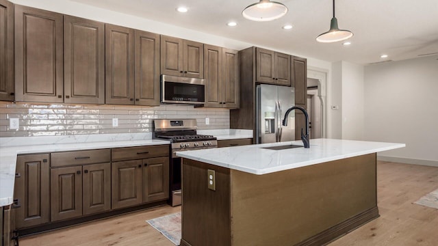 58 Lippert Ln, Buckeye Lake, OH 43008 - kitchen with stainless steel appliances, tasteful backsplash, light wood-style flooring, hanging light fixtures, and light stone counters