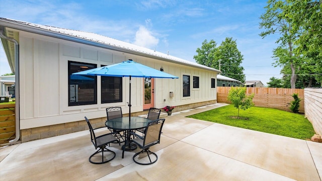 58 Lippert Ln, Buckeye Lake, OH 43008 - back of house with board and batten siding, a patio, outdoor dining area, and a metal roof