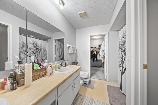 1290 Paddington Ct, Columbus, OH 43230 - bathroom featuring tile patterned floors, vanity, a textured ceiling, and a spacious closet