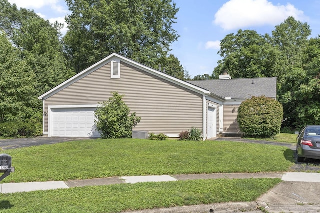 1290 Paddington Ct, Columbus, OH 43230 - view of side of property featuring a lawn, driveway, a garage, and a chimney
