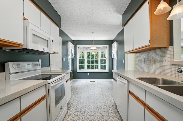 6281 Mcnaughten Place Ln Unit 24, Columbus, OH 43213 - kitchen featuring white appliances, light countertops, tasteful backsplash, white cabinets, and a textured ceiling