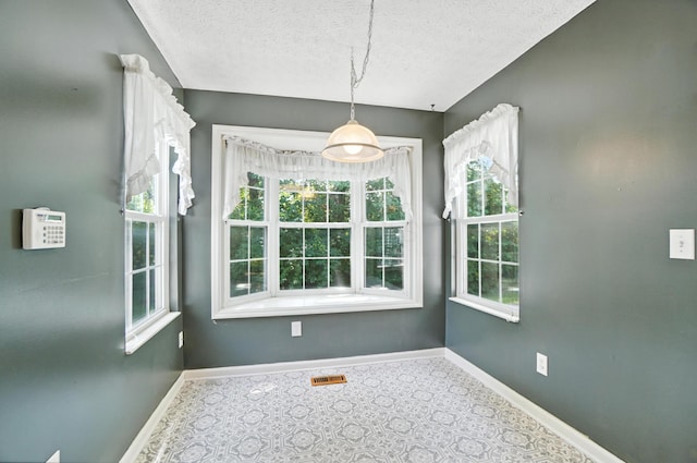 6281 Mcnaughten Place Ln Unit 24, Columbus, OH 43213 - unfurnished dining area with a textured ceiling and baseboards