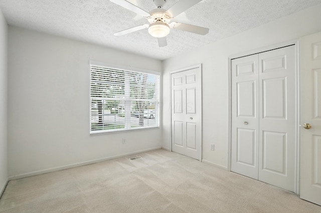 6281 Mcnaughten Place Ln Unit 24, Columbus, OH 43213 - unfurnished bedroom featuring multiple closets, a textured ceiling, carpet, and ceiling fan