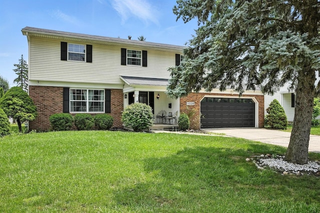 5328 Torchwood Loop E, Columbus, OH 43229 - view of front of home with driveway, an attached garage, a front lawn, and brick siding
