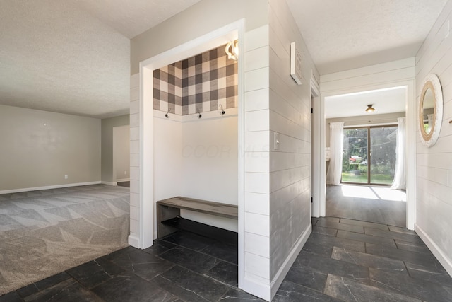 1242 Springbrook Dr, Mansfield, OH 44906 - mudroom featuring a textured ceiling, stone tile flooring, and carpet