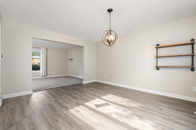 1242 Springbrook Dr, Mansfield, OH 44906 - unfurnished room with a chandelier, wood finished floors, and a textured ceiling