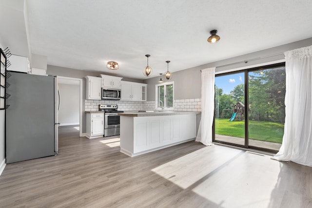 1242 Springbrook Dr, Mansfield, OH 44906 - kitchen with appliances with stainless steel finishes, a peninsula, white cabinets, and tasteful backsplash