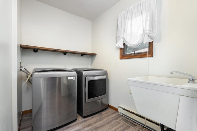 1242 Springbrook Dr, Mansfield, OH 44906 - washroom with a baseboard radiator, washing machine and dryer, and light wood-type flooring