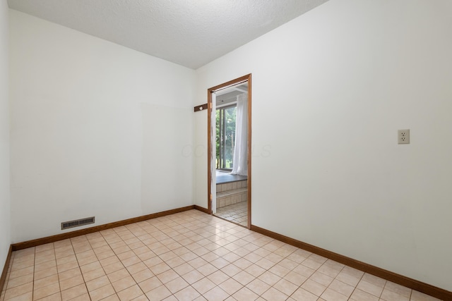 1242 Springbrook Dr, Mansfield, OH 44906 - empty room with a textured ceiling and light tile patterned flooring