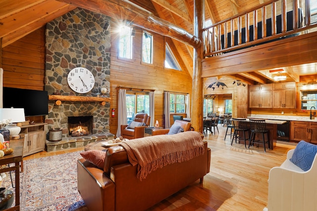 16651 Skinner Rd, Logan, OH 43138 - living area featuring a wooden ceiling with exposed beams, light wood-style flooring, high vaulted ceiling, a stone fireplace, and wood walls