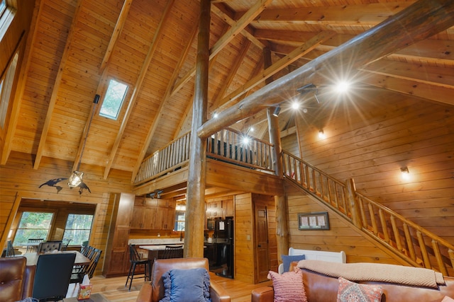 16651 Skinner Rd, Logan, OH 43138 - living room with a towering ceiling, stairs, a wood ceiling with exposed beams, wood walls, and light wood finished floors