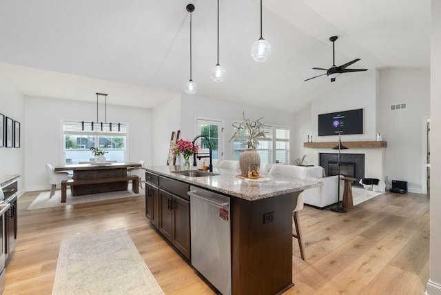 4881 Hoover Rd, Grove City, OH 43123 - kitchen with dishwasher, dark brown cabinetry, a fireplace, ceiling fan, and light wood-type flooring